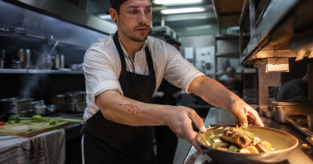 Cocinero preparando un plato en una de las vacantes gastronómicas de Hipódromo de Palermo