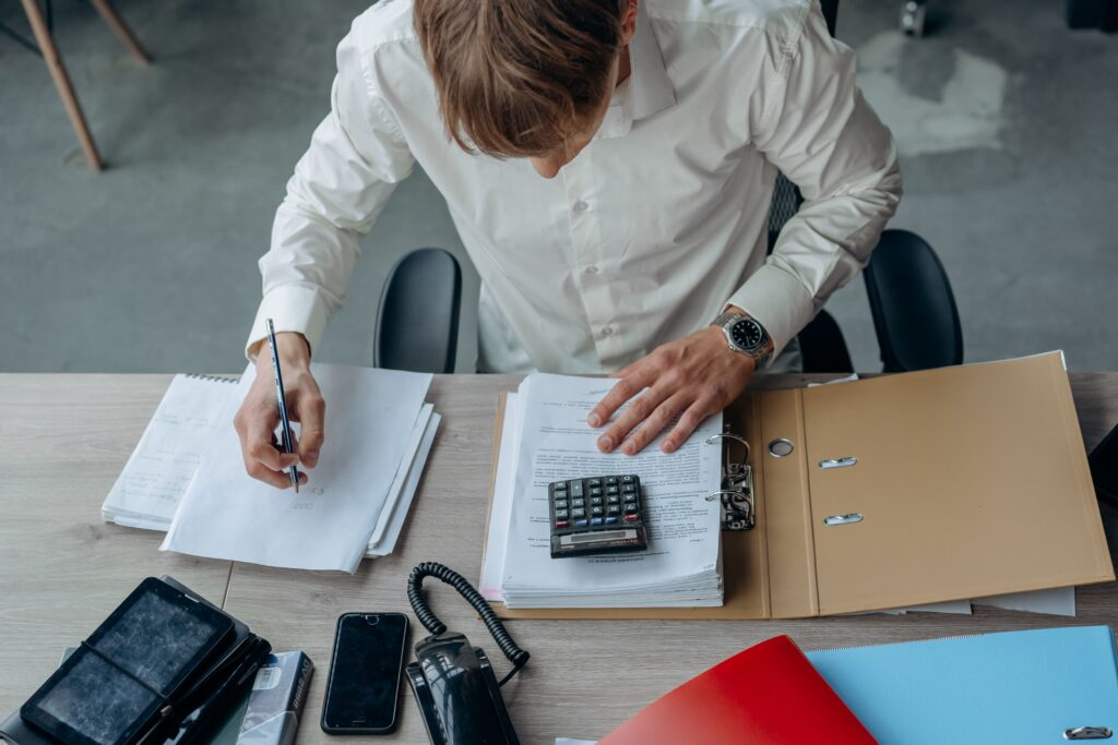 persona revisando una liquidación de sueldo y calculando cifras con una calculadora.